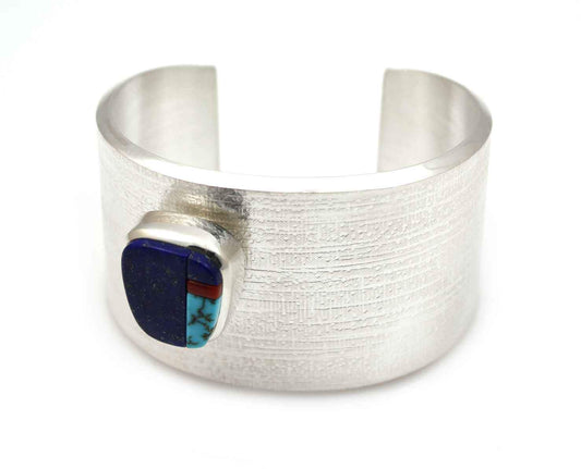 Sterling silver with lapis, coral and Lone Mnt turquoise. 1 1/2" wide, size 6
