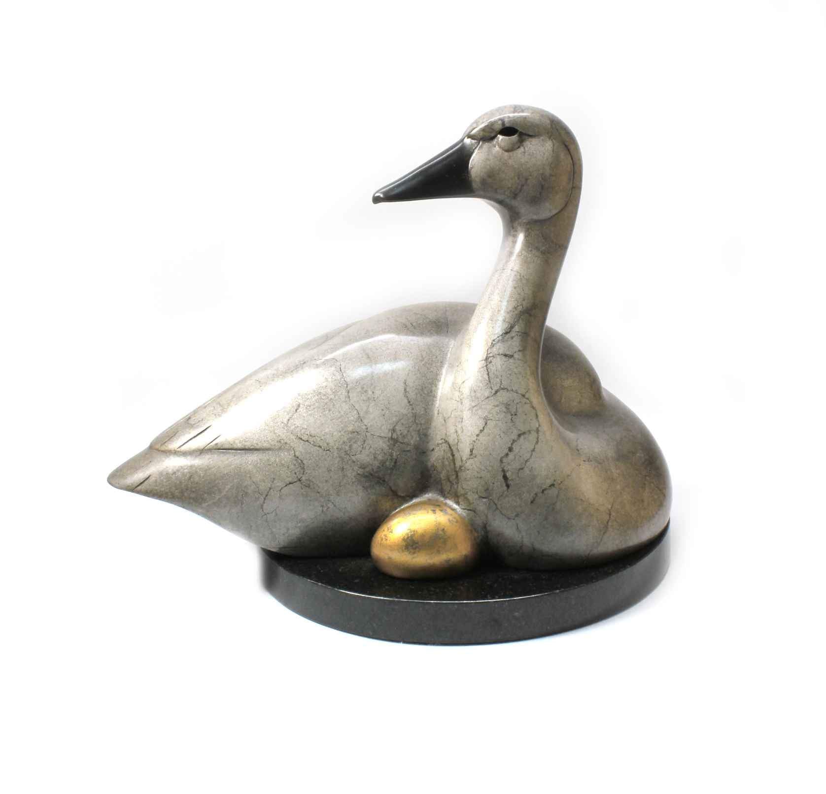 A Gray swan nestling a golden egg. Bronze sculpture by Tim Cherry. Sorrel Sky Gallery.