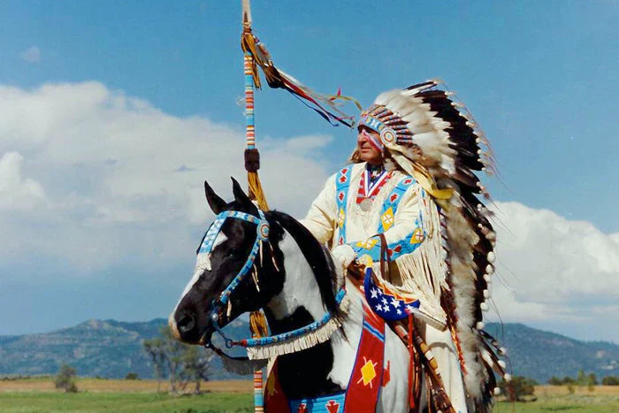 Ben Nighthorse in full Native regalia riding his horse Scamp. Featured Santa Fe Art Gallery  jewelry artist.