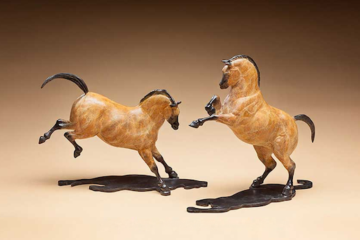 bronze sculptures of two horses, one rearing and one bucking